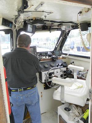 Capt. Dave Duvall checks his GPS systems and listens in on a potential call for service in the pilothouse of the Sea-Cure at the Watergate Village docks in Annapolis, Maryland, on September 24. Capital News Service photo by Dylan Moroses