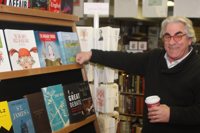Tom Martin at teh Bookplate bookstore taking a break from inventorying hundreds of new books.