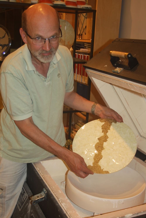 Dave Hegland removing a bowl from the 'slumping' process whre each piece is given its shape. 