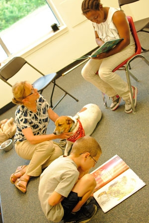 Jane Welsh, President of the Humane Society of Kent County, with Reggie, listening to their readers. Photo by Carolyn Thompson.