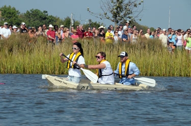 Staff and students from the College's Center for Environment & Society paddle their own entry to the finish line of the 2012 cardboard boat race. From left, they are Shannon Denno '14,  Hugh McKeever '13, and Mike Hardesty.