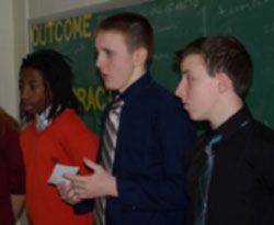 Ninth grade STEM student Tyler Cullum, center, answers a question about his proposal to put exercise bicycles in a few Kent County High School classrooms.  Studies show that when students exercise, he said, blood flow to the brain increases by 30 percent.  Silas Phillips is at left; Zach Argo is at right.