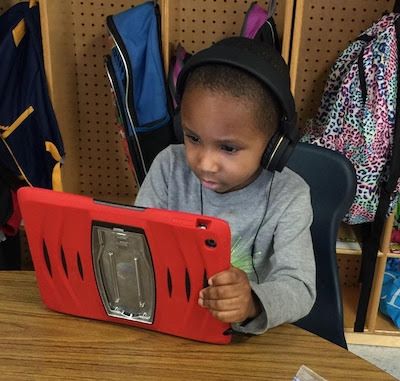 Kindergarten student Jayden Robertson Walker uses an iPad to practice reading skills.