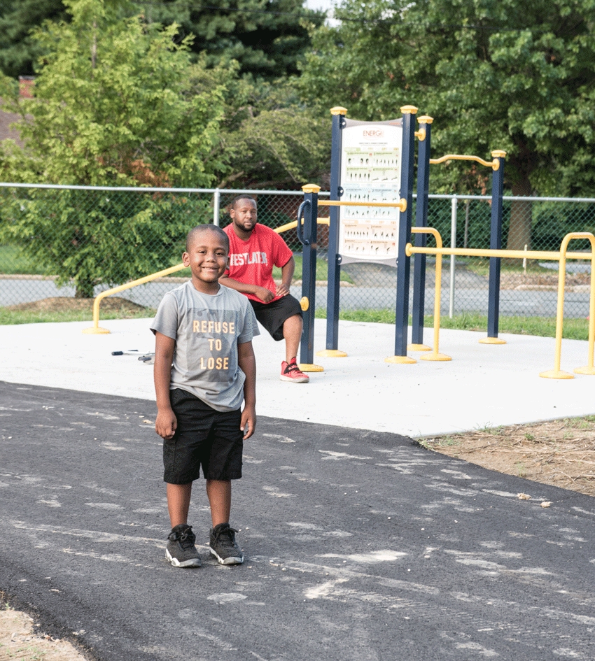 Ry'mir Wilson tries out the new track at Kent County Middle School. His father, Reggie Wilson sits at one of the workout stations newly installed there.