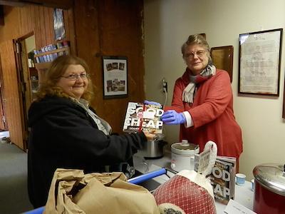 Volunteer Charlotte Hawes gives out samples and a copy of the cookbook that provides families easy nutritious recipes to make on a food stamp budget.